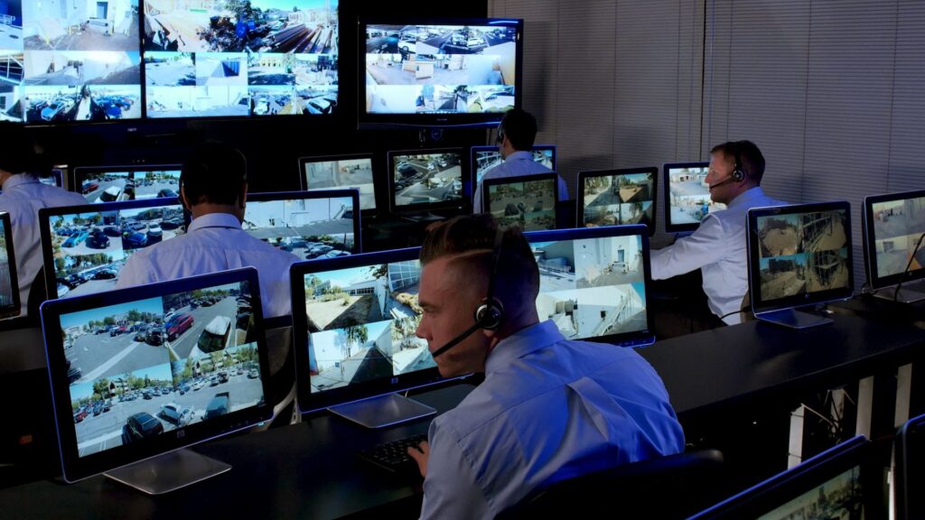 Live monitoring agent watching multiple camera feeds at a professional security operations center in Los Angeles