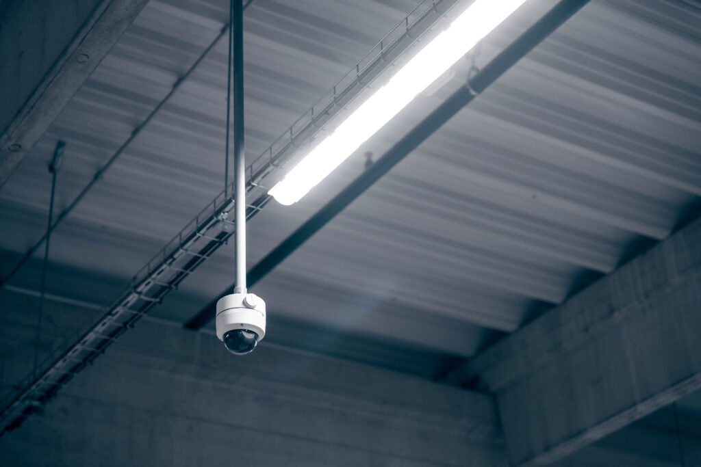Interior warehouse security camera monitoring aisles and loading dock areas